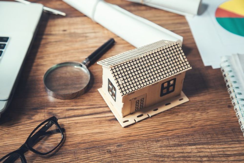 A house model kept with a magnifying glass on table