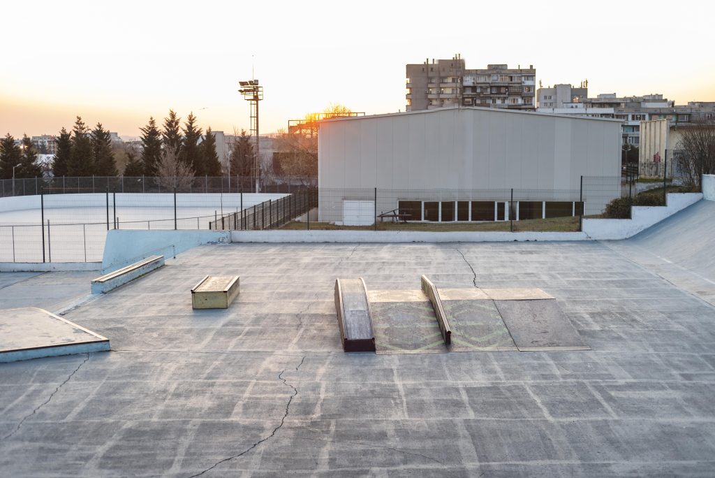 Flat concrete rooftop with installed ramps and open space, viewed at sunset.